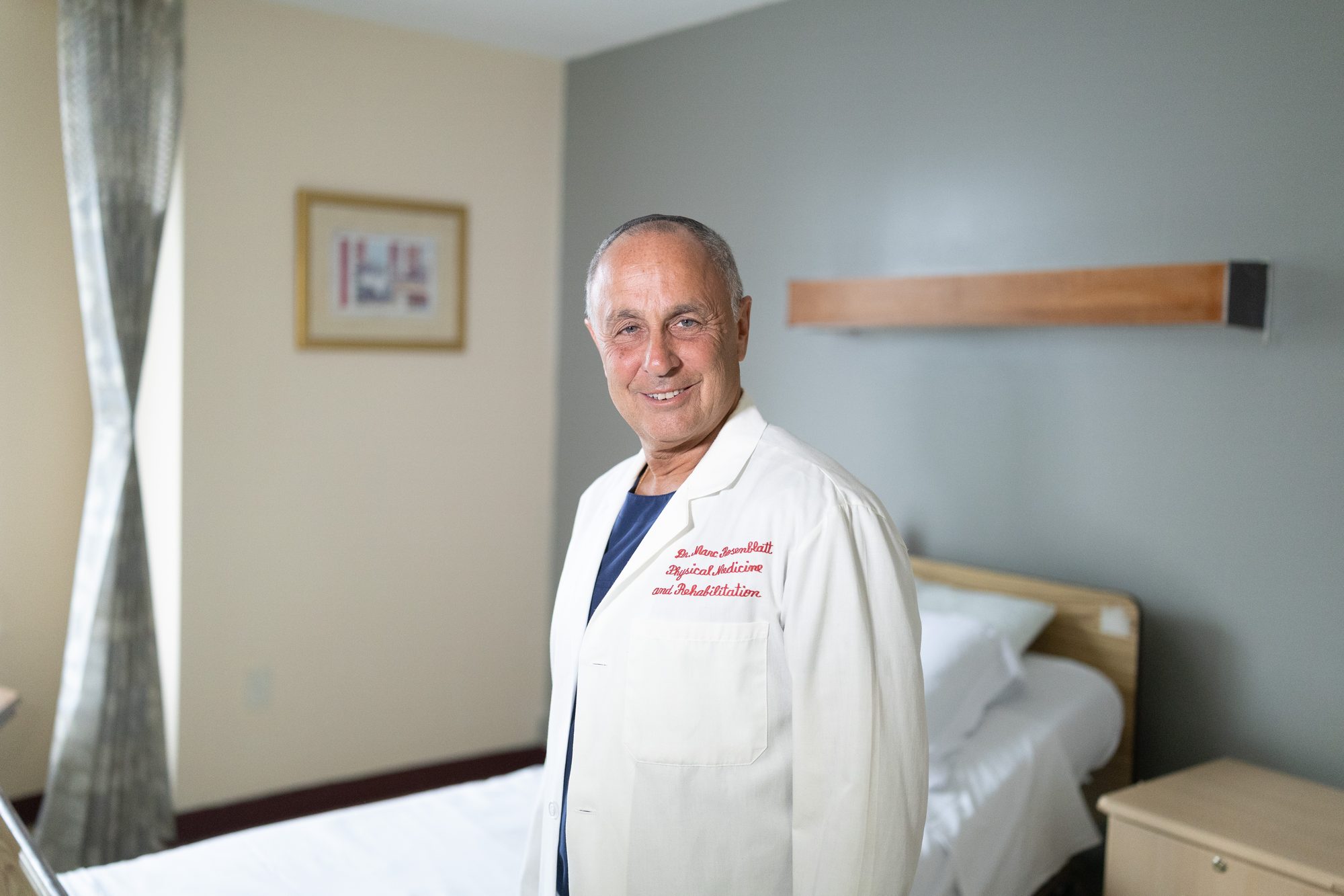 Dr. Marc Rosenblatt in a white coat in a patient room