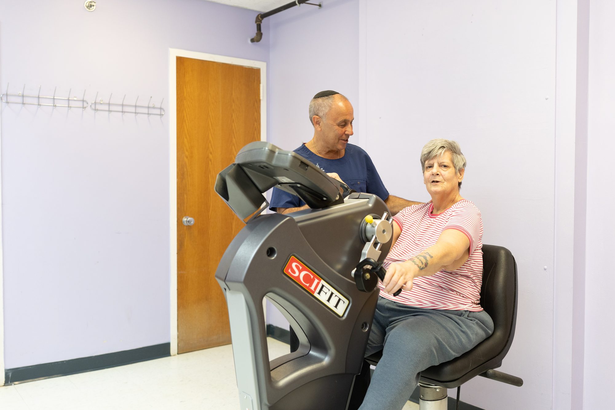Dr. Marc Rosenblatt with a patient using a SciFit upper body ergometer